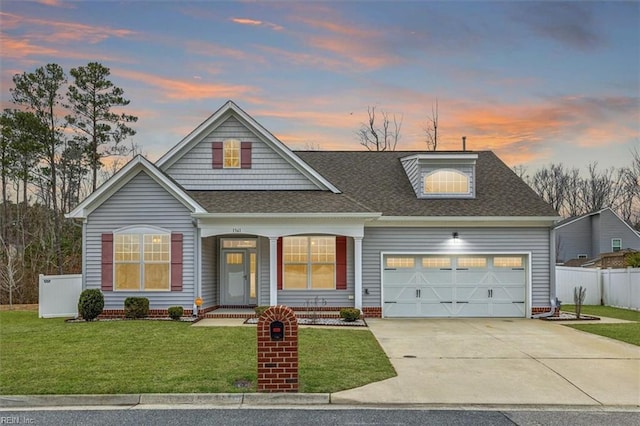 view of front of property with a garage and a yard