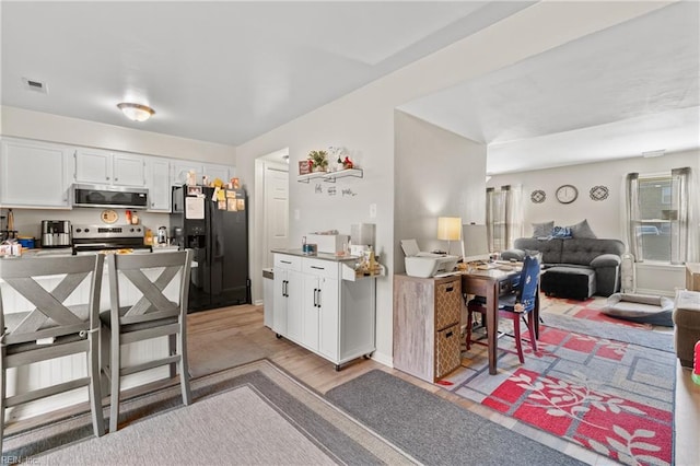 kitchen featuring white cabinetry, appliances with stainless steel finishes, and light hardwood / wood-style floors