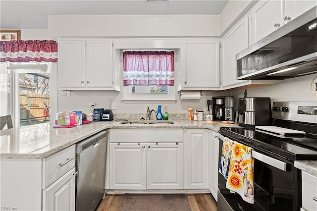 kitchen featuring stainless steel appliances, light stone countertops, sink, and white cabinets