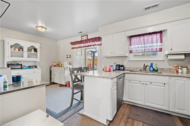 kitchen with sink, dishwasher, white cabinetry, light stone countertops, and dark hardwood / wood-style flooring