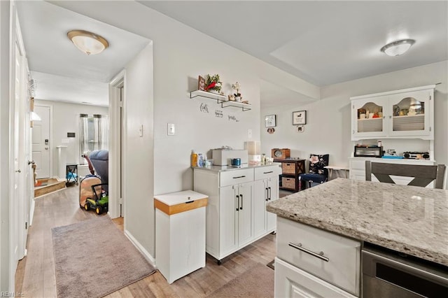 kitchen featuring white cabinetry, light stone countertops, and light hardwood / wood-style floors