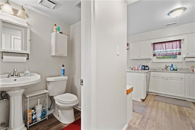 bathroom with wood-type flooring and toilet