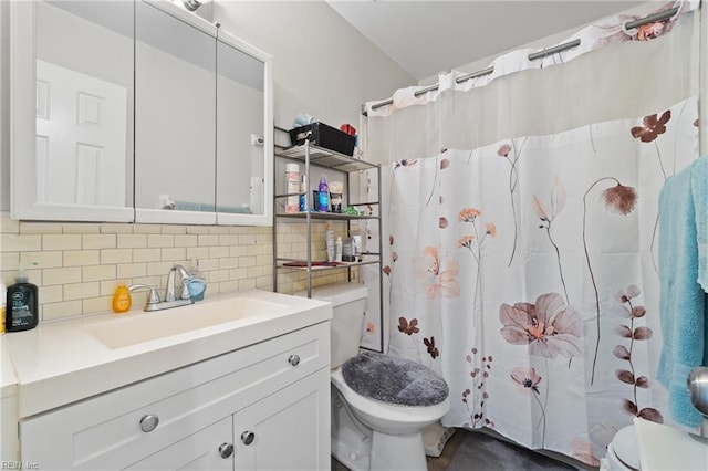 bathroom featuring vanity, curtained shower, backsplash, and toilet