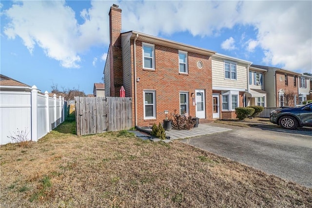 rear view of property with a patio area and a lawn