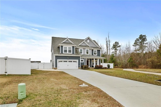 view of front of house featuring a porch, a garage, and a front lawn