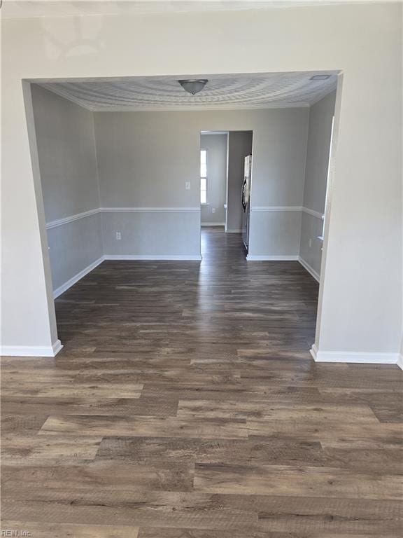 spare room featuring crown molding and dark hardwood / wood-style floors