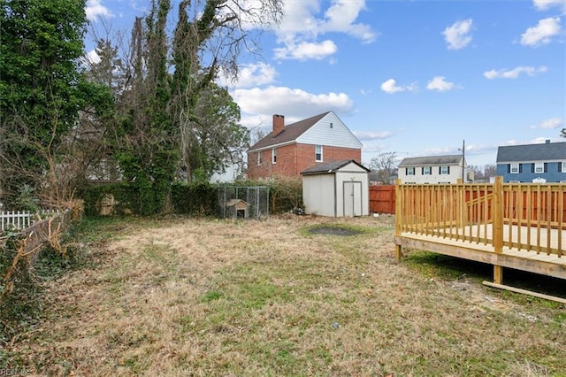 view of yard with a wooden deck and a storage unit