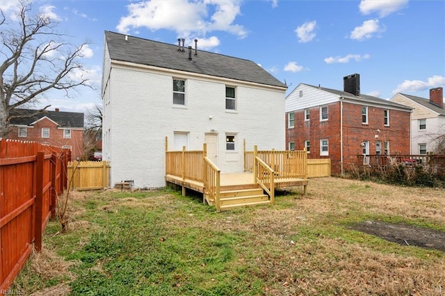 rear view of property featuring a yard and a deck