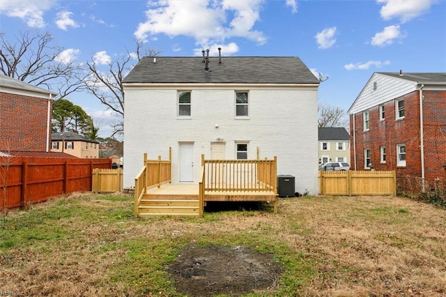 back of property with a lawn, central air condition unit, and a deck