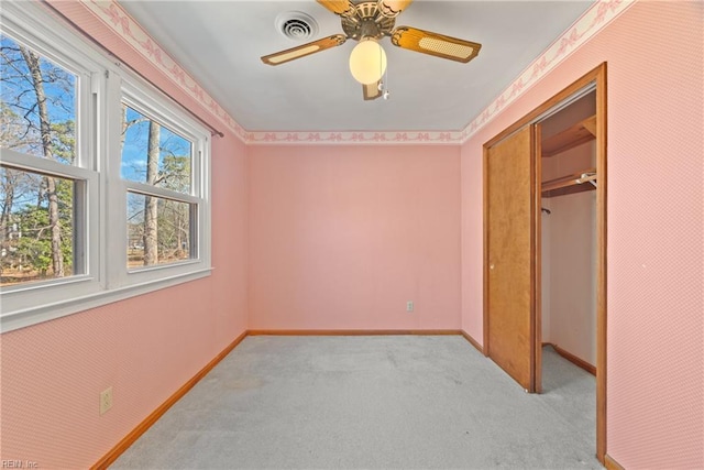 unfurnished bedroom with ceiling fan, light colored carpet, and a closet