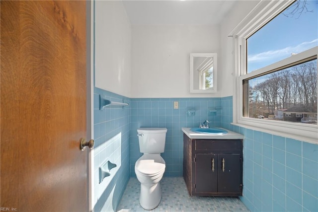 bathroom with vanity, tile walls, and toilet