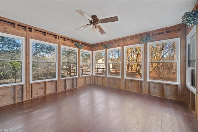 unfurnished sunroom featuring ceiling fan and a healthy amount of sunlight