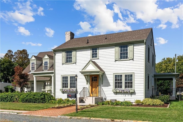 colonial-style house featuring a front lawn