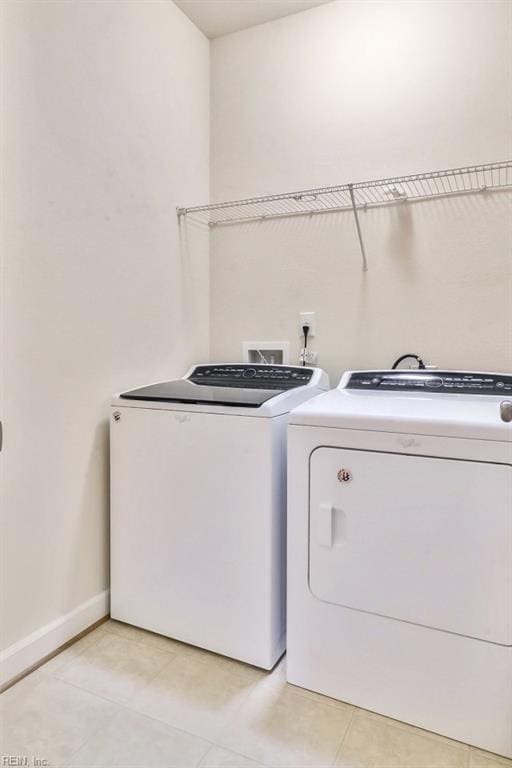 washroom with washing machine and clothes dryer and light tile patterned flooring