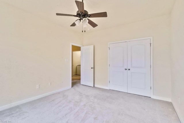 unfurnished bedroom featuring ceiling fan, light colored carpet, and a closet