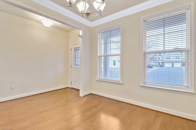 unfurnished room with an inviting chandelier, hardwood / wood-style floors, and crown molding