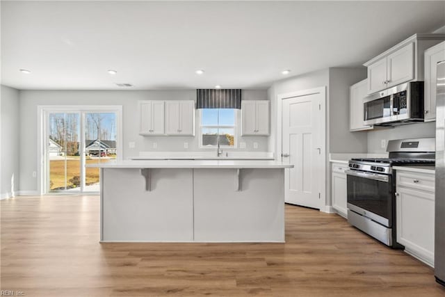 kitchen with white cabinetry, stainless steel appliances, and a center island