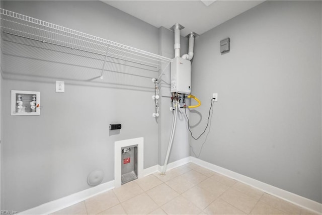 clothes washing area featuring hookup for a washing machine, water heater, and light tile patterned floors