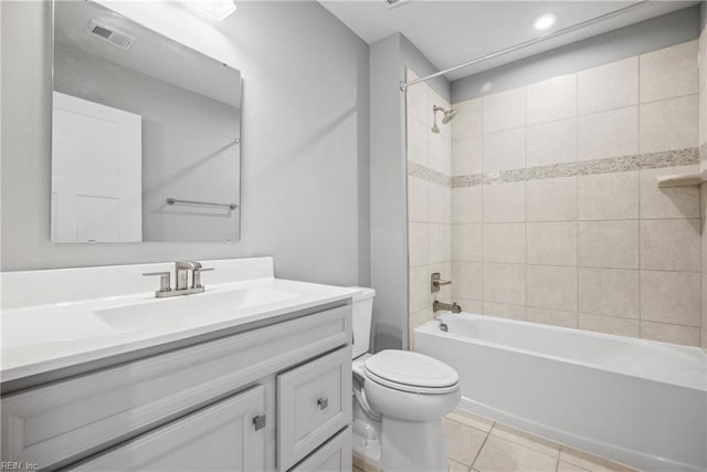 full bathroom featuring tiled shower / bath, tile patterned floors, toilet, and vanity