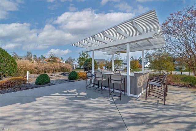 view of patio with a bar and a pergola