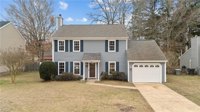 colonial inspired home featuring a garage and a front lawn