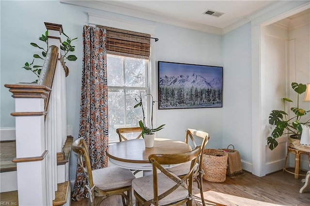 dining room with wood-type flooring and ornamental molding