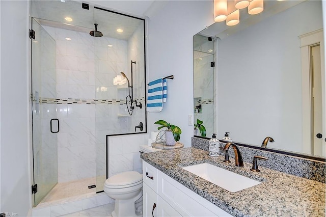 bathroom with vanity, toilet, and a shower with door