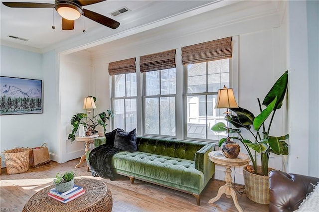 interior space with hardwood / wood-style flooring, ceiling fan, and ornamental molding