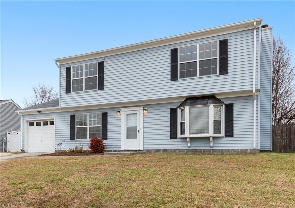 view of front of property with a garage and a front lawn