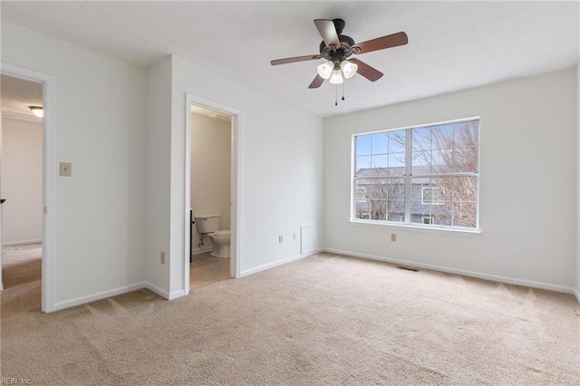 unfurnished bedroom with connected bathroom, light colored carpet, and ceiling fan