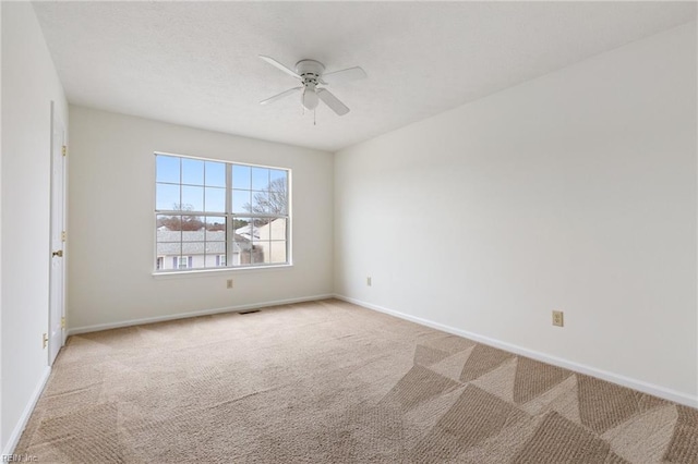 spare room featuring ceiling fan and light carpet