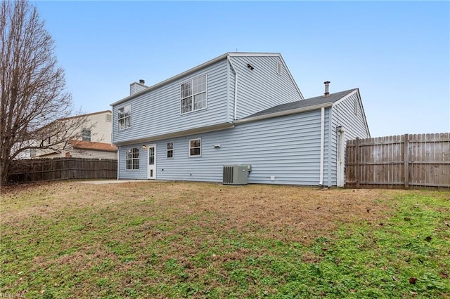 back of property featuring a yard and central air condition unit