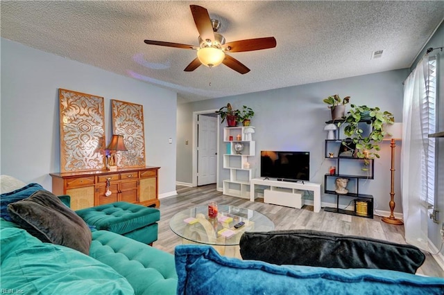 living room with ceiling fan, hardwood / wood-style floors, and a textured ceiling