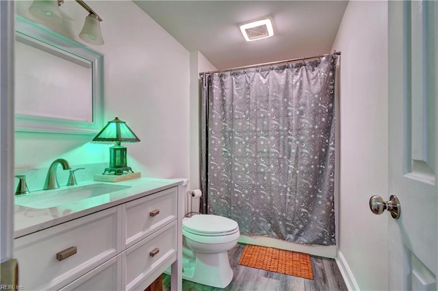 bathroom featuring vanity, wood-type flooring, toilet, and walk in shower