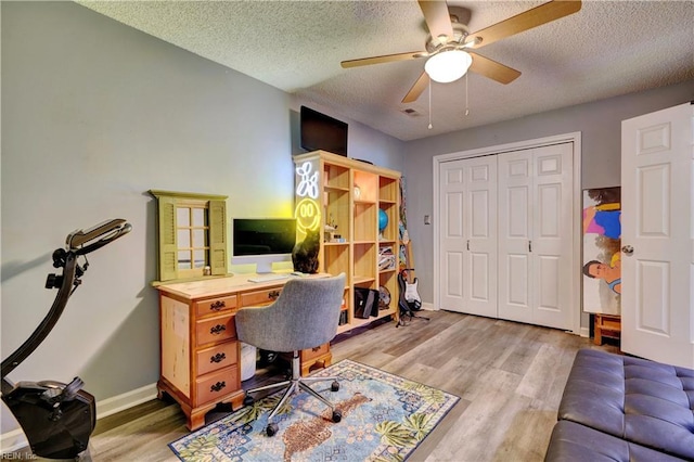 office area featuring ceiling fan, light hardwood / wood-style floors, and a textured ceiling