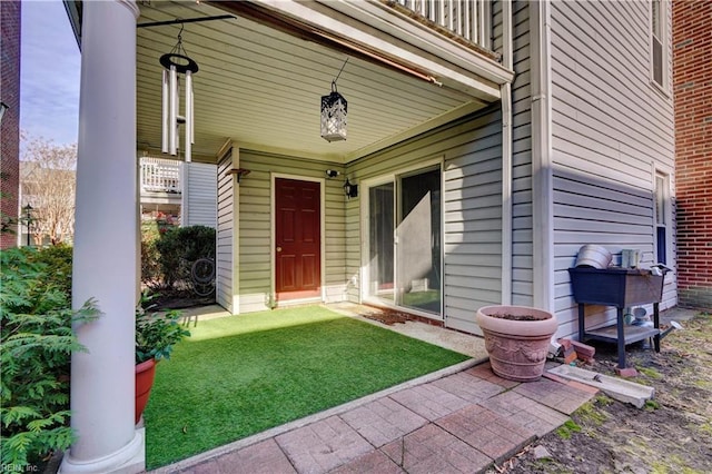 property entrance featuring a balcony and a yard