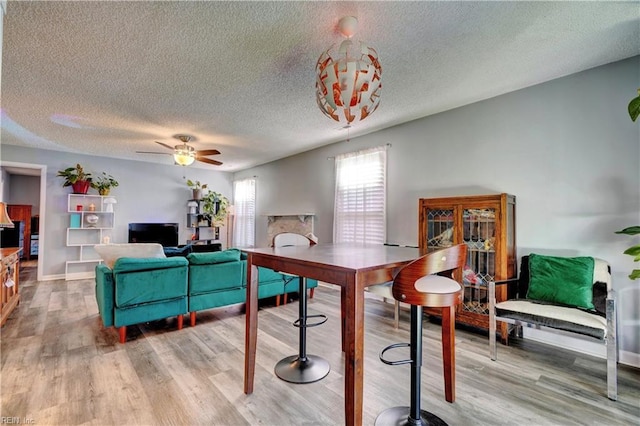 dining room featuring hardwood / wood-style floors, a textured ceiling, and ceiling fan