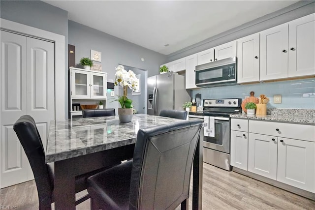 kitchen featuring light stone countertops, white cabinets, and appliances with stainless steel finishes