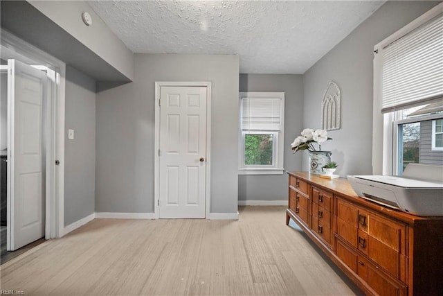 bedroom with a textured ceiling and light wood-type flooring