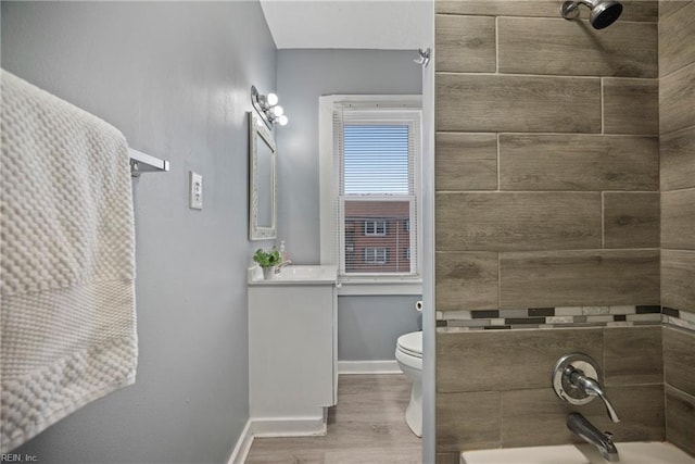 full bathroom with vanity, hardwood / wood-style flooring, tiled shower / bath combo, and toilet