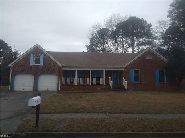 single story home featuring a porch, a garage, and a front yard