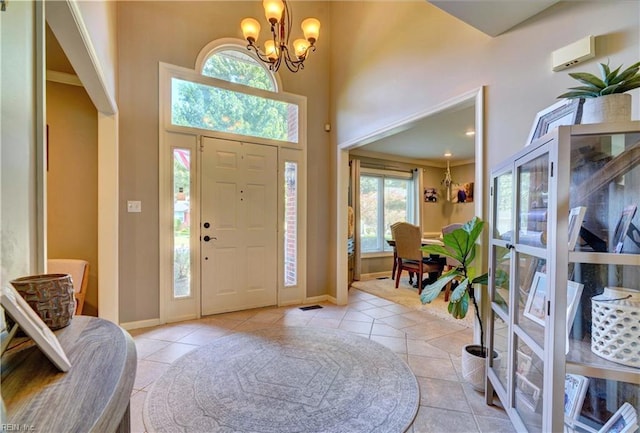 tiled entryway with a high ceiling and a chandelier