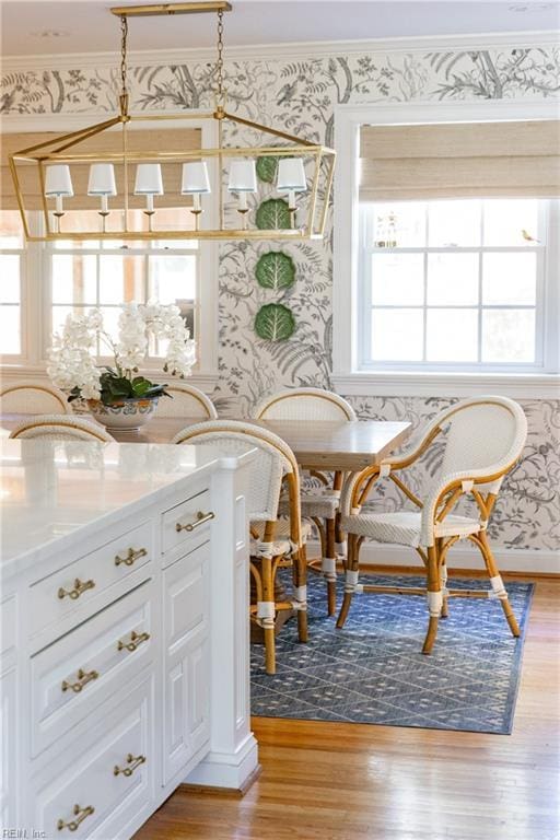 interior space featuring breakfast area, crown molding, and light hardwood / wood-style flooring