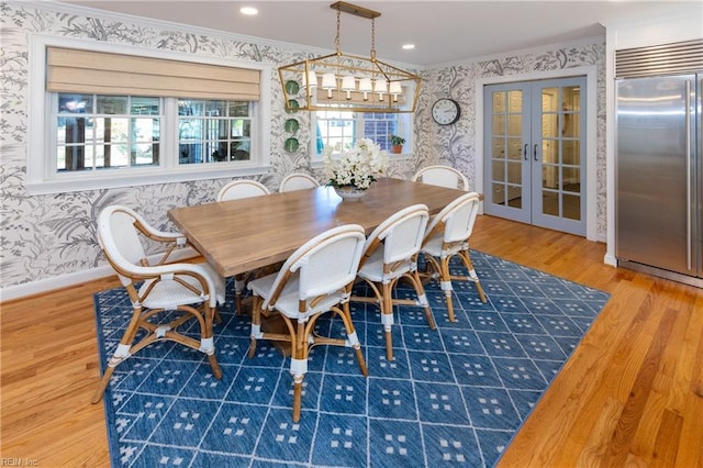 dining space with french doors, crown molding, and hardwood / wood-style floors