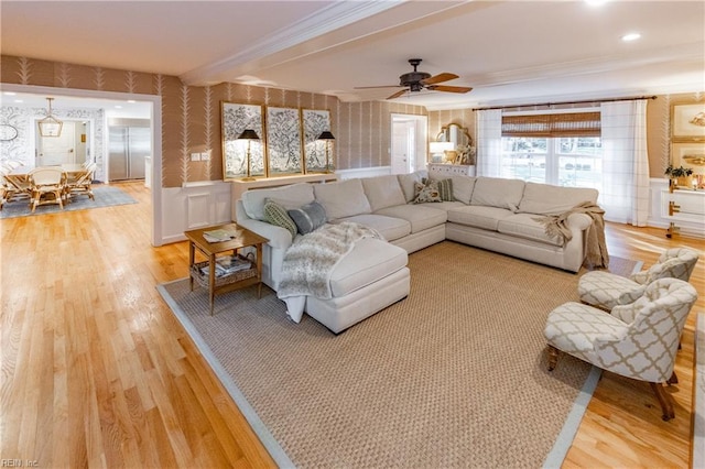 living room featuring crown molding, ceiling fan, and light wood-type flooring