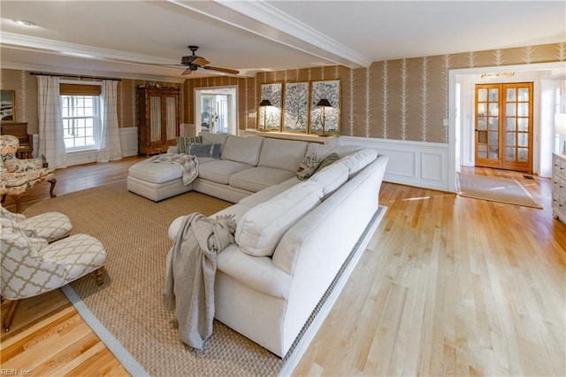 living room with crown molding, ceiling fan, and light wood-type flooring