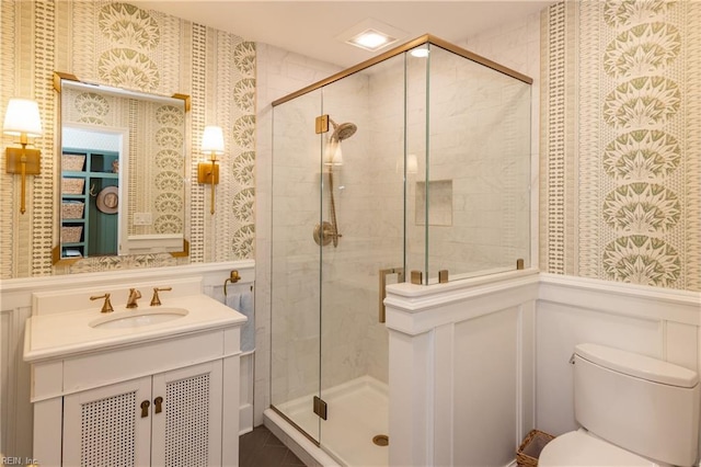 bathroom featuring walk in shower, vanity, and toilet