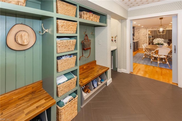 mudroom featuring dark parquet flooring and crown molding