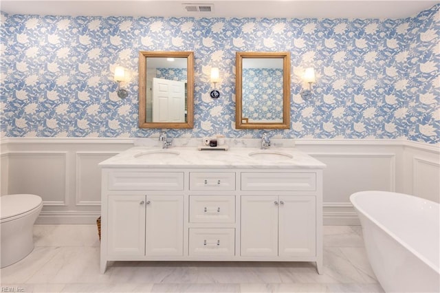 bathroom with vanity, a tub, and toilet