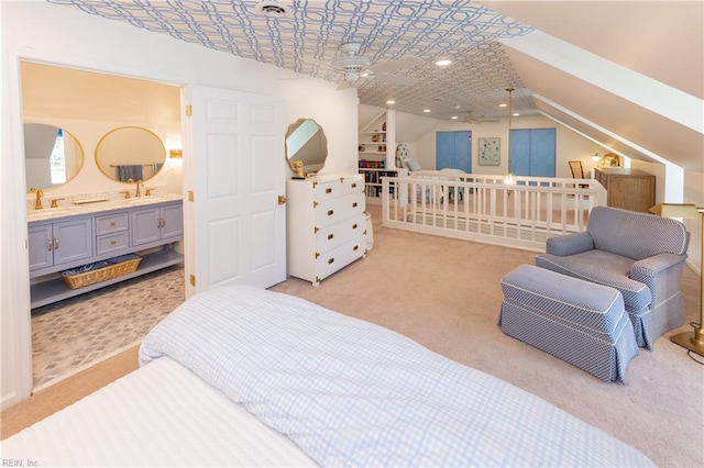 carpeted bedroom featuring lofted ceiling and ensuite bath